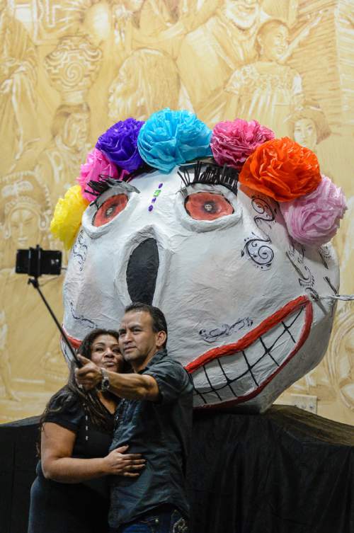 Francisco Kjolseth | The Salt Lake Tribune
Beatriz and Carlos Miron take a picture of themselves in front of a large paper mache skull as people gather for the 12th annual Day of the Dead at the Utah Cultural Celebration Center in West Valley City on Sunday, Nov. 1, 2015. Una Mano Amiga constructed a central altar, surrounded by many community altars and Dia de Los Muertos-themed vignettes, creating a colorful, creative and informative exhibition. Authentic Mexican food, music, dance, ceremonies, games, vendors, activities and art stations were also part of the celebration.