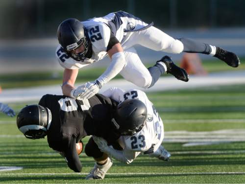 Steve Griffin  |  The Salt Lake Tribune

Highland receiver Ryan Lambson gets tackled by Corner Canyon's Perry Sandun, top, and Calvin Millich during the Class 4A quarterfinal football game at Highland High School in Salt Lake City, Friday, November 6, 2015.