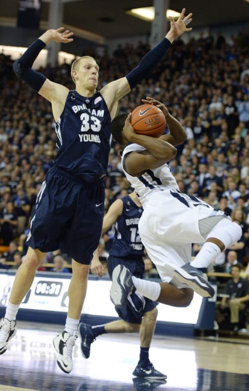 Steve Griffin  |  The Salt Lake Tribune

Brigham Young Cougars forward Nate Austin (33) leaps above Utah State Aggies guard Darius Perkins (2) as Perkins tries to get a shot off during second half action in the BYU versus USU men's basketball game in Logan, Tuesday, December 2, 2014.