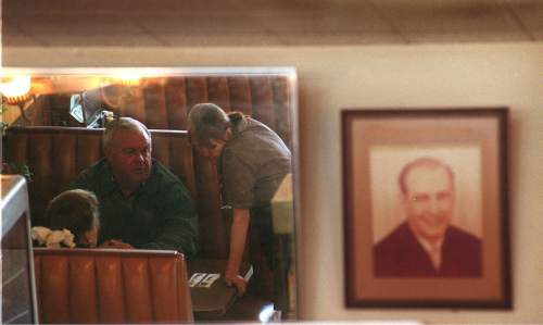 Leah Hogsten  |  Tribune File Photo 

"I know everybody by name," says waitress Sharon Livingston above, reflected in a mirror waiting on a customer.  The late Bill McHenry greets patrons from a photo hanging on the back wall. After over 50 years of service to Salt Lake City, Bill and Nada's Cafe closed its doors December 22, 1999. "It breaks my heart," said Livingston who has worked at the cafe for 11 years. "I cry everyday." Photographed Nov. 22, 1999.