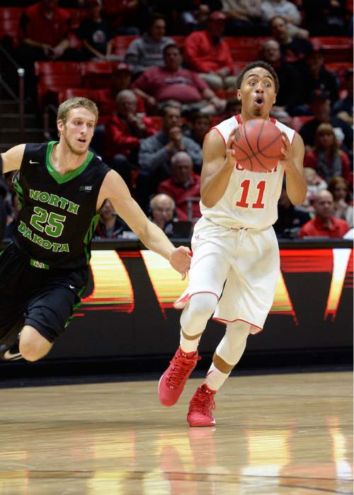 Scott Sommerdorf   |  The Salt Lake Tribune
Utah Utes guard Brandon Taylor (11) fakes aa alley-oop pass while guarded by North Dakota Fighting Sioux guard Dustin Hobaugh (25) during first half play. Utah led North Dakota 37-26 at the half of the Utah Thanksgiving Tournament, Friday November 28, 2014