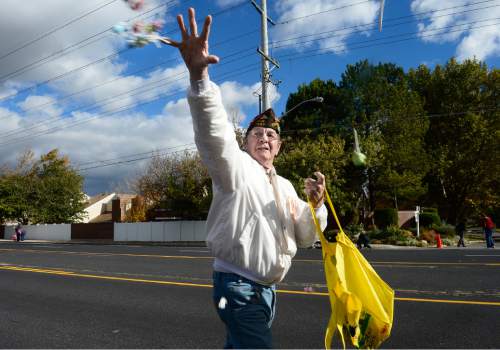 Scott Sommerdorf   |  The Salt Lake Tribune
VFW member and veteran Bill Ganton tosses candy at kids at the Taylorsville Veteran's Day Parade, Wednesday, November 11, 2015.