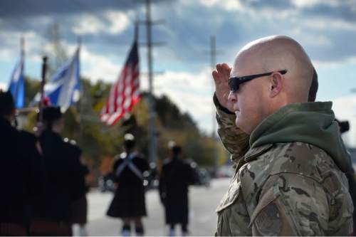 Scott Sommerdorf   |  The Salt Lake Tribune
Police Officer Ryan Wolf salutes as the flag passes him as the Taylorsville Veteran's Day Parade began, Wednesday, November 11, 2015.