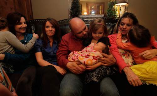 Leah Hogsten  |  The Salt Lake Tribune
Polygamist Joe Darger and his wives l-r Alina, Valerie and Vicki watch as daughter Krista, 4, holds 3-day old sister Alexandra Tess, the newest member of the family while Victoria, 3, kisses Vicki. The Darger's celebrated the ruling handed down by U.S. District Court judge Clark Waddoups that key parts of Utah's polygamy laws are unconstitutional, December 13, 2013. "For the first time in my lifetime--and in the last 100 years, we don't have a cloud over our heads," said Joe of the ruling. "This is historic."