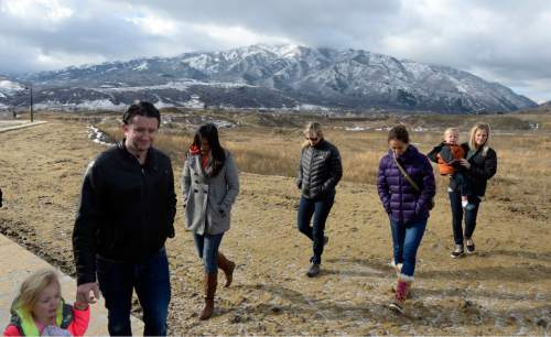 Al Hartmann  |  The Salt Lake Tribune
Rollins Ranch residents Jordan Hansen, with daughter Sunday, Emily Mendenhall, Amy Johnson, Nina Rhoades, and Rachel Hogge, and son Austin walk from a vacant building lot lookingon the edge of an old gravel quarry below the subdivision. They are  alarmed about plans to reactivate two old gravel quarries that now abut residential neighborhood near Trapper's Loop Road and I-84.  The Warner pit, the one Staker-Parson is seeking a permit from Morgan County to resume operations lies just a few feet behind them.
