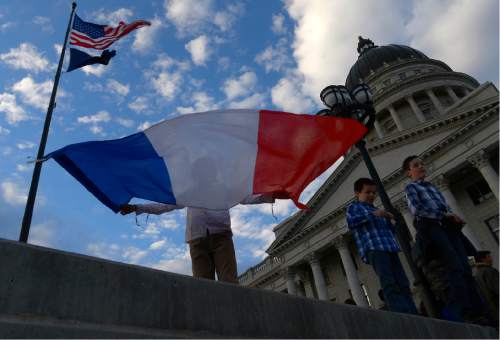 Leah Hogsten  |  The Salt Lake Tribune
Astrid Viollet unfurls the French flag while attending the vigil with her mother and brothers Calixte and Theodore, right. French organizations, including Alliance FranÁaise de Salt Lake City, held a vigil at the Utah Capitol, in the wake of the terrorist attacks in Paris to show support for the City of Light and its people. The remembrance was followed by a religious vigil at 5 p.m., Sunday, November 15, 2015.