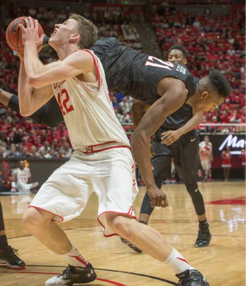 Rick Egan  |  The Salt Lake Tribune

Utah Utes forward Jakob Poeltl (42) goes up for a shot, as San Diego State Aztecs forward Malik Pope (21) tumbles off his back, in basketball action, as the Utes defeated the San Diego State Aztecs 81-76, at the Huntsman Center, Tuesday, November 10, 2015.