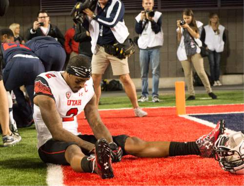 Rick Egan  |  The Salt Lake Tribune

Utah Utes wide receiver Kenneth Scott (2), sits in the endzone, after the Utes failed to score on the last play of the game, as the Wildcats celebrate their 37-30 win over the Utes in double overtime, in PAC-12 action against the Arizona Wildcats, in Tucson, Saturday, November 14, 2015.