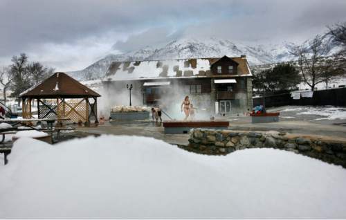 Scott Sommerdorf  |  Salt Lake Tribune

With a snowbank in the foreground, the main pool and building at Crystal Hot Springs are seen in Honeyville, Utah against a background of snow covered mountains.