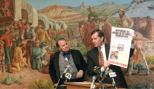 Al Hartmann  |  The Salt Lake Tribune

Gov. Mike Leavitt holds a newspaper insert to show at kickoff of Envision Utah at This Is the Place Sate Park.  "Brigham Young" actually a  good planner for his time looks on.    "Brigham" is actually James Arrington.