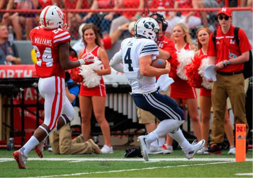 BYU quarterback Taysom Hill (4) is chased by Nebraska safety Aaron Williams (24) as he runs for a touchdown during the first half of an NCAA college football game in Lincoln, Neb., Saturday, Sept. 5, 2015. (AP Photo/Nati Harnik)