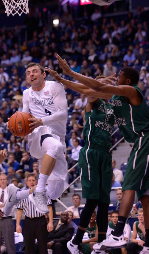 Leah Hogsten  |  The Salt Lake Tribune
Brigham Young Cougars guard Nick Emery (4) slides past Adams State Grizzlies guard Shakir Smith (5) and Adams State Grizzlies guard EJ Hubbard II (0) for two. Brigham Young University leads Adams State Grizzlies, 42-29 at the halfNovember 20, 2015 at Marriott Center, Provo.