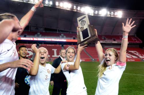 Scott Sommerdorf   |  The Salt Lake Tribune
Davis players Ireland Dunn, left, Haylee Cacciacarne, center, and Reygn Youngberg, right, celebrate as others rush in to grab a piece of he trophy after Davis beat Weber 1-0 for the girl's 5A title at Rio Tinto stadium, Friday, October 23, 2015.