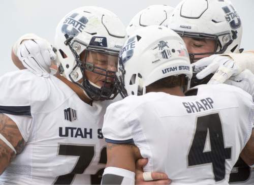 Rick Egan  |  The Salt Lake Tribune

Utah State Aggies offensive lineman Tyshon Mosley (72) and other team mates celebrate the touchdown catch by Utah State Aggies wide receiver Hunter Sharp (4), in college football action, Utah State vs Colorado State at Maverik Stadium in Logan, Saturday, October 3, 2015.
