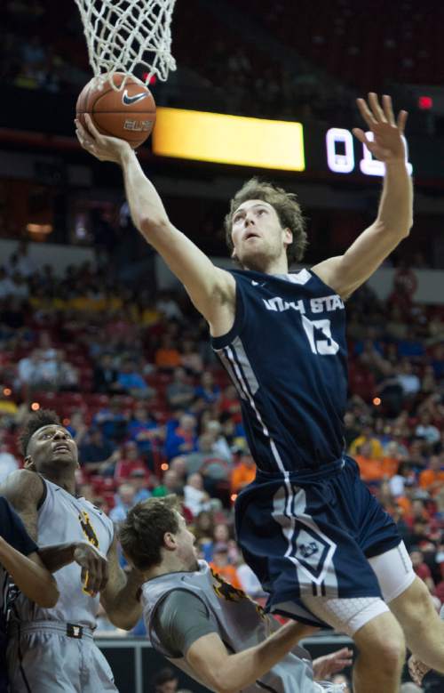 Rick Egan  |  The Salt Lake Tribune

Utah State Aggies forward David Collette (13)  goes in for a shot over Wyoming Cowboys guard Riley Grabau (2) in Mountain West Conference Basketball Championship action, Utah State vs. Wyoming, at the Thomas & Mack Center in Las Vegas, Thursday, March 12, 2015.