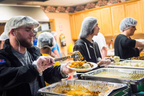 Chris Detrick  |  The Salt Lake Tribune
Volunteer Brandon Stott serves yams during Salt Lake City Mission's 22nd annual Thanksgiving Day Dinner For The Homeless at the Christian Life Center Thursday November 26, 2015.