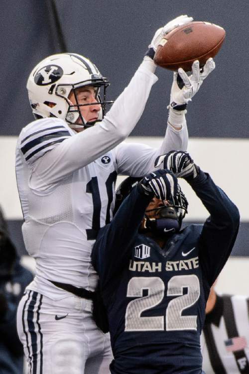 Trent Nelson  |  The Salt Lake Tribune
Brigham Young Cougars wide receiver Mitch Mathews (10) pulls in a touchdown reception over Utah State Aggies cornerback Bryant Hayes (22) as Utah State hosts BYU, NCAA football in Logan, Saturday November 28, 2015.