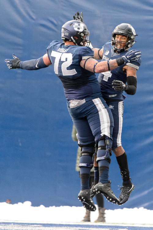 Trent Nelson  |  The Salt Lake Tribune
Utah State Aggies offensive lineman Tyshon Mosley (72) and Utah State Aggies wide receiver Hunter Sharp (4) celebrate a touchdown reception by Sharp, as Utah State hosts BYU, NCAA football in Logan, Saturday November 28, 2015.