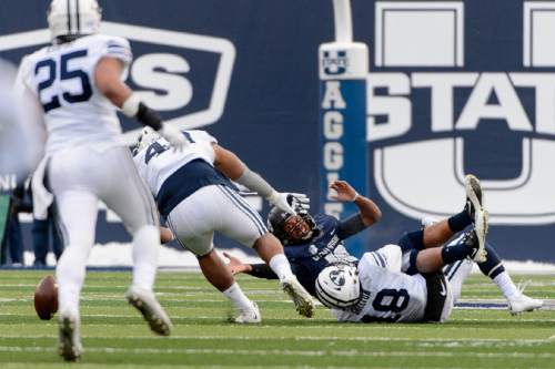 Trent Nelson  |  The Salt Lake Tribune
Brigham Young Cougars defensive lineman Tomasi Laulile (48) picks up a fumble by Utah State Aggies quarterback Chuckie Keeton (16), which he ran into the end zone for a touchdown, as Utah State hosts BYU, NCAA football in Logan, Saturday November 28, 2015.