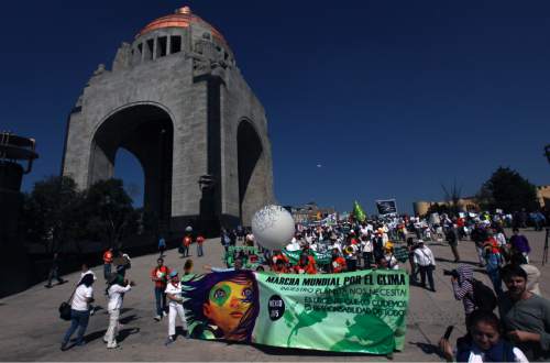 People march during a protest for Global Climate next to the Monument to the Revolution in Mexico City, Sunday, Nov. 29, 2015. The march came as the leaders of more than 140 countries prepare to converge on Paris to launch two weeks of high-stakes talks to try to hash out the broadest, most lasting deal to date to slow global warming. (AP Photo/Marco Ugarte)