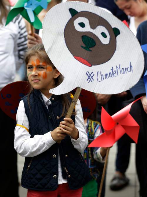 A girls takes part in a silent march calling for ambitious action to tackle climate change, in Bogota, Colombia, Sunday, Nov. 29, 2015. The group urges decisive actions from world leaders who will gather in Paris for the 21st Conference of Parties (COP 21) of the United Nations Framework Convention on Climate Change. (AP Photo/Fernando Vergara)