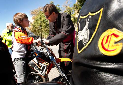 Leah Hogsten | The Salt Lake Tribune
 Casey Mullins, 8, gets his KTM 65 motorcycle blessed by the Very Reverend Ray Waldon, Saturday, September 28, 2013 during the "8th Annual Blessing of the Bikes" at the Cathedral Church of St. Mark. The event was aimed at raising awareness of bicycle safety for anyone on on or two wheels including scooters, bicycles, motorcycles, unicycles, tricycles,