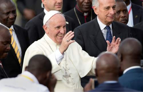 Pope Francis greets traditional dancers on his arrival at the airport in Nairobi, Kenya Wednesday, Nov. 25, 2015. Pope Francis left Wednesday for his first-ever visit to the continent, a whirlwind pilgrimage to Kenya, Uganda and the Central African Republic, bringing a message of peace and reconciliation to an Africa torn by extremist violence. (AP Photo/Ben Curtis)