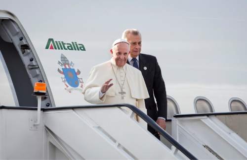 Pope Francis waves as he departs from his plane on his arrival at the airport in Nairobi, Kenya, Wednesday, Nov. 25, 2015. Pope Francis left Wednesday for his first-ever visit to the continent, a whirlwind pilgrimage to Kenya, Uganda and the Central African Republic, bringing a message of peace and reconciliation to an Africa torn by extremist violence. (AP Photo/Ben Curtis)