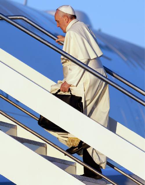 Pope Francis boards an airplane at Rome's Fiumicino International Airport, Wednesday, Nov. 25, 2015. Pope Francis is leaving for a trip that will take him to Kenya, Uganda and the Central African Republic, from Nov. 25-30. (AP Photo/Gregorio Borgia)