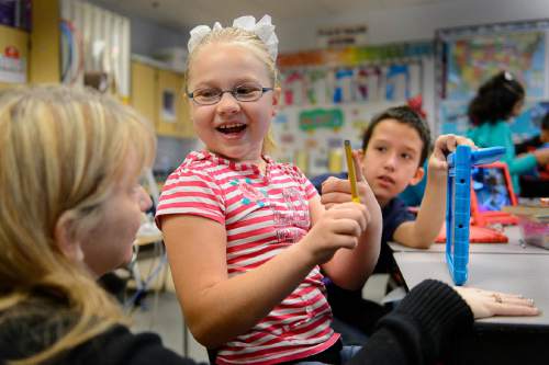 Trent Nelson  |  The Salt Lake Tribune
Newman Elementary fifth-grader Mikaila Koffard gets help from teacher Angelique Morrill while working on a class project on an iPad, in Salt Lake City, Tuesday November 17, 2015. At right is Eddie Adams. The project was meant to answer the question of magnets, how do they work?