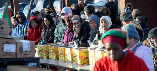 Al Hartmann  |  The Salt Lake Tribune
Bundled up women wait to receive  holiday food boxes and baskets on a cold Thursday Dec. 3 morning at Mosaic Inter-faith Ministries at 4392 S. 900 E.  300 families received food boxes today.  
Mosaic Inter-faith Ministries is a multi-cultural center, formerly named Lutheran Social Service of Utah. Volunteers from Victory Outreach Men in Recovery as well as Mosaic's diverse volunteers will pass out the food. Mosaic is planning a Dec. 8 event for children, pre-teens and teenagers to get gift bags, and a Dec. 9 event for the first 250 families to be given vouchers to Deseret Industries or Crossroads Urban Center.