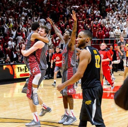 Trent Nelson  |  The Salt Lake Tribune
Utah Utes guard Brandon Taylor (11) leaps into Jakob Poeltl's arms to celebrate as the University of Utah Utes defeats the Wichita State Shockers in overtime, 69-68, college basketball at the Huntsman Center in Salt Lake City, Wednesday December 3, 2014. At right is Utah Utes guard Delon Wright (55).