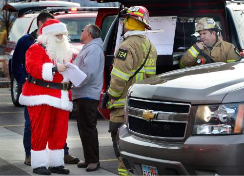 Scott Sommerdorf   |  The Salt Lake Tribune
UFA fire investigator Don Buckley - in the Santa suit - works with other investigators to try to pinpoint the source of the two-alarm fire at the Loveland Living Aquarium in Draper, Sunday, December 13, 2015. Buckley happened to be at the aquarium with his with Judy (Mrs. Claus), meeting with children when the fire started. The fire was limited to the rooftop, and no animals were affected in the aquarium.