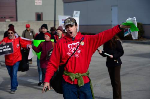 Scott Sommerdorf   |  The Salt Lake Tribune
Demonstartion organizer Ryan Pleune leads group of demonstrators to the public area outside the Exxon station after the protest's 27 minutes expired. Environmental activist demonstrators blockaded this Exxon station in Murray with red lines meant to symbolize Exxon's closure, which the activists demand as retribution for the company's alleged role in denying climate change, Saturday, December 12, 2015.