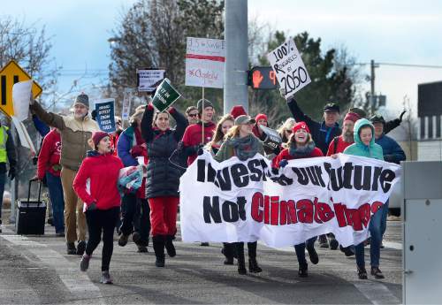 Scott Sommerdorf   |  The Salt Lake Tribune
Environmental activist demonstrators joyously ran across 4500S prior to blockading an Exxon station in Murray with red lines meant to symbolize Exxon's closure. Activists demand the closure as retribution for the company's alleged role in denying climate change, Saturday, December 12, 2015.