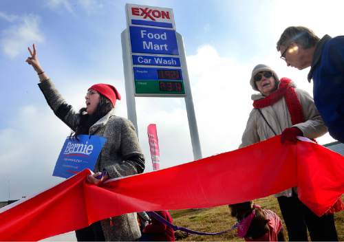 Scott Sommerdorf   |  The Salt Lake Tribune
Environmental activist demonstrators blockaded this Exxon station in Murray with red lines meant to symbolize Exxon's closure, which the activists demand as retribution for the company's alleged role in denying climate change, Saturday, December 12, 2015.