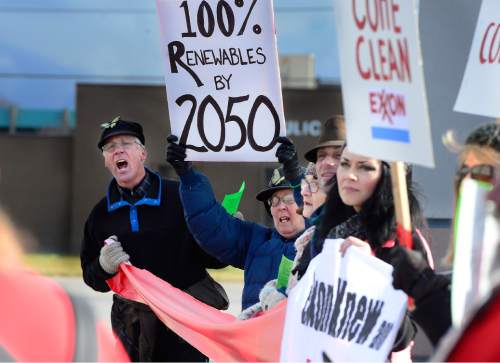 Scott Sommerdorf   |  The Salt Lake Tribune
Michael Dowd, aka "Reverend Reality" sings as environmental activist demonstrators blockaded this Exxon station in Murray with red lines meant to symbolize Exxon's closure, which the activists demand as retribution for the company's alleged role in denying climate change, Saturday, December 12, 2015.