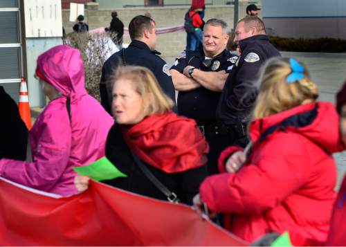 Scott Sommerdorf   |  The Salt Lake Tribune
Murray police were patient as they waited for the demonstrators 27 minutes of protest time to pass. Environmental activist demonstrators blockaded this Exxon station in Murray with red lines meant to symbolize Exxon's closure, which the activists demand as retribution for the company's alleged role in denying climate change, Saturday, December 12, 2015.