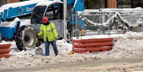 Al Hartmann  |  The Salt Lake Tribune
Construction worker tries to keep work area and pedestrian way clear of snow at 100 South and Main St. in Salt Lake City as the city digs out from yesterday's record breaking snowfall Tuesday Dec. 15.