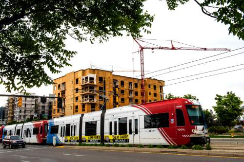 Chris Detrick  |  The Salt Lake Tribune
TRAX train zips past apartment construction along 400 South and 500 East on Tuesday, May 12, 2015.