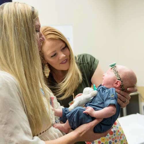 Rick Egan  |  The Salt Lake Tribune

Melissa Fox,  (left) RN at Intermountain Medical Center, holds Lucy,  Arlee Gregerson's baby, at the Intermountain Medical Center.  When Lucy was two days old, Arlee Gregerson nearly died, but thanks to the swift CPR action by Melissa Fox, and life-saving coordination of medical teams at Intermountain Medical Center in Murray, Arlee and her baby are both doing well. They returned to the hospital to reunite with the doctors and nurses who saved her life one month ago. Thursday, December 17, 2015.