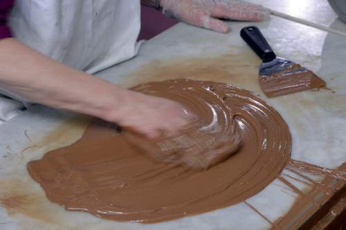 Al Hartmann  |  The Salt Lake Tribune
Brenda Roundy, who works at Mrs. Cavanaugh's factory in North Salt Lake, has been hand-dipping chocolate for about 15 years. She has it down to near perfection.  She works the milk chocolate under correct temperature and humidity  to create the right consistency before adding almonds and finally dipping the chocolate mixture into small paper cups for milk chocolate almond clusters, a popular treat for the holidays.