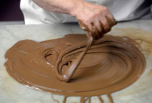 Al Hartmann  |  The Salt Lake Tribune
Brenda Roundy, who works at Mrs. Cavanaugh's factory in North Salt Lake, has been hand-dipping chocolate for about 15 years. She has it down to near perfection.  She works the milk chocolate under correct temperature and humidity  to create the right consistency before adding almonds and finally dipping the chocolate mixture into small paper cups for milk chocolate almond clusters, a popular treat for the holidays.