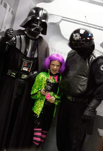 Francisco Kjolseth  |  Tribune file photo
Darth Vader and a death star operator pose for a photo with Tiffany Bible, 11, of Murray in 2011 at the Murray Library. Star Wars characters will be at the library this Saturday to celebrate the traditional "May the Fourth Be With You" Star Wars Day.