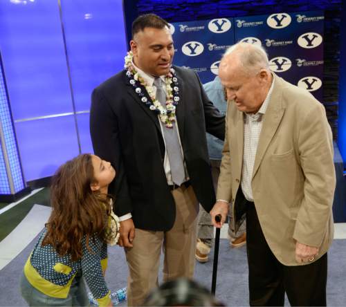 Al Hartmann  |  The Salt Lake Tribune
BYU's new head coach Kalani Sitaki talks with his old head coach Lavell Edwards after a press conference in Provo Monday Dec. 21.   His youngest daughter, left.
