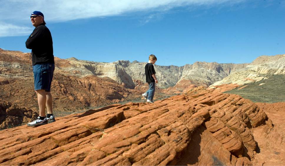 Danny Patten, left, and his son Spencer Patten, 5, take in the awe inspiring 360 degree view of Snow Canyon State Park after hiking to the top of a stair-like petrified sand dune mounain.  Al Hartmann/Salt Lake Tribune   3/19/08