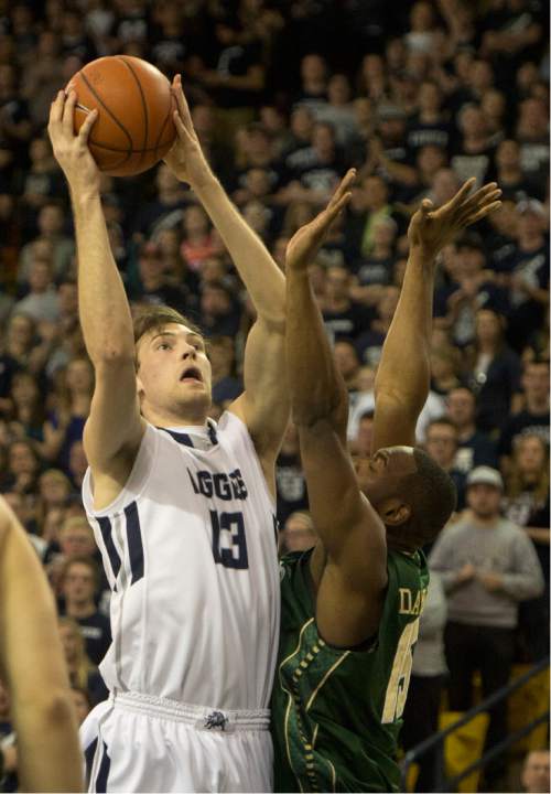 Rick Egan  |  The Salt Lake Tribune

Utah State Aggies forward David Collette (13) takes a shot, as Colorado State Rams forward Tiel Daniels (15) defends, in basketball action, Utah State vs. Colorado State, in Logan, Saturday, March 7, 2015