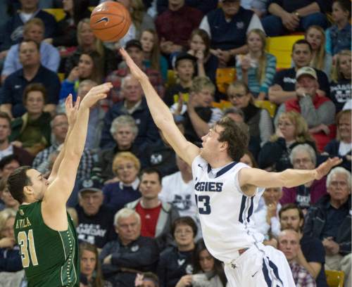 Rick Egan  |  The Salt Lake Tribune

Colorado State Rams forward J.J. Avila (31) shoots over Utah State Aggies forward David Collette (13), in basketball action, Utah State vs. Colorado State, in Logan, Saturday, March 7, 2015