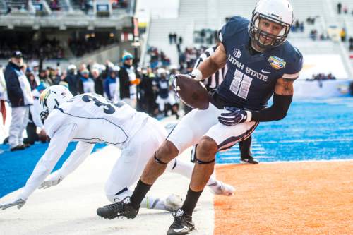 Chris Detrick  |  The Salt Lake Tribune
Utah State Aggies wide receiver Brandon Swindall (11) scores a touchdown past Akron Zips safety Zach Guiser (32) during the Famous Idaho Potato Bowl at Albertsons Stadium in Boise, Idaho Tuesday December 22, 2015.  Akron Zips lead Utah State Aggies 13-7 at halftime.