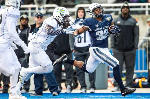 Chris Detrick  |  The Salt Lake Tribune
Utah State Aggies running back Devante Mays (32) runs past Akron Zips linebacker Jatavis Brown (1) during the Famous Idaho Potato Bowl at Albertsons Stadium in Boise, Idaho Tuesday December 22, 2015.  Akron Zips lead Utah State Aggies 13-7 at halftime.